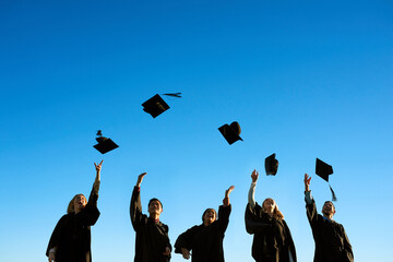 Education, graduation and throwing with student friends outdoor on campus for celebration or...