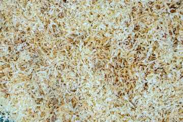 Close-up yellow wood chipping, mulch created by cutting wood with chainsaw to be recycled on plants. Top view.