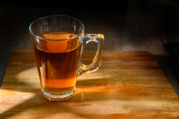 Warm tea in a glass cup on a rustic table