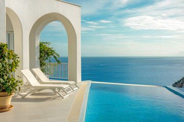 Fototapeta premium sun loungers on the terrace with arch and pool with beautiful sea views. Luxury vacation this summer on your trip