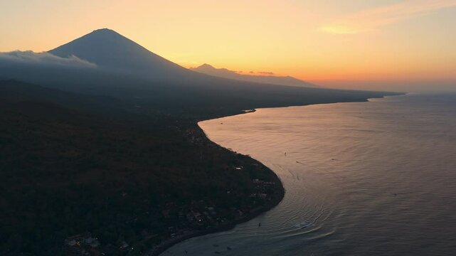Coastline and volcano mountain on bright sunset. Drone view in Amed, Bali
