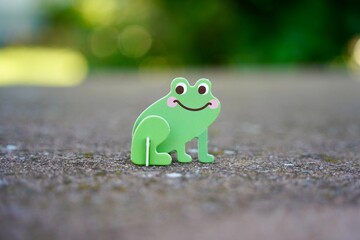 Small cute green frog cardboard figure. Animal figurine toy.