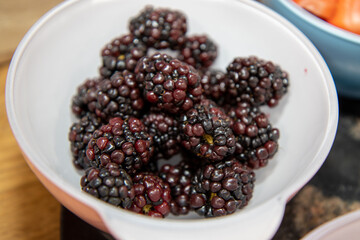 A bowl of delicious red raspberries in a white bowl