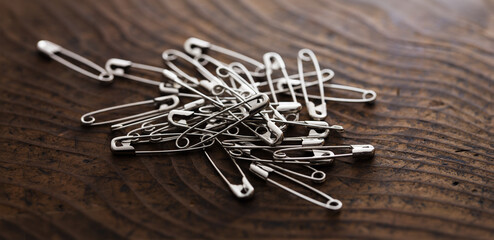 Safety pins on or a pin on a rustic wooden table.
