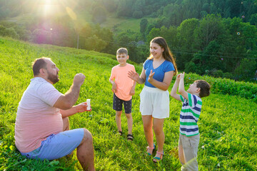 Father and kids having fun and blowing soap bubbles.