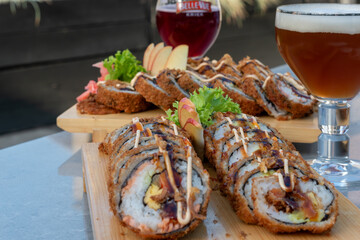 Rolls and sushi on a plate surrounded by vegetables and spices, Sushi and rolls, Japanese sea cuisine,Dragon Rolls at home,  Roll is another popular sushi roll serve, 