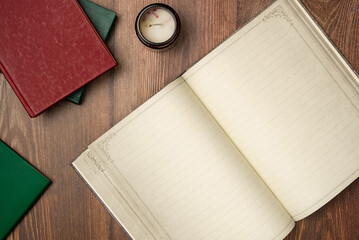 Open empty notebook in vintage style with books on wooden background from above. Flat lay, top...