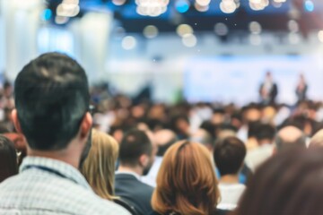A man in a suit is looking at a crowd of people. The crowd is full of people wearing suits and ties