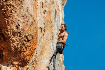 male rock climber climbs a rock. sports and outdoor recreation. sporty guy doing rock climbing.