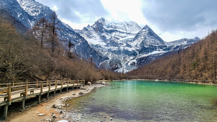 Scenic pearl lake with green color water with mount Xiannairi as backdrop at Yading Nature Reserve, Sichuan, China