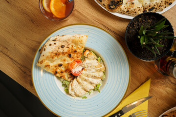 Caesar salad with fried chicken slices, tomato, parmesan cheese, tomato and crispy focaccia