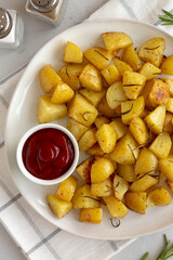 Homemade Oven Roasted Potatoes with Ketchup on a Plate, top view.