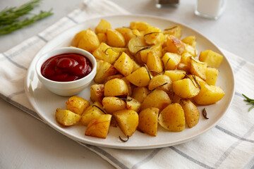 Homemade Oven Roasted Potatoes with Ketchup on a Plate, side view.