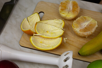 Orange peel and pulp on kitchen counter while using fruits in fruit smoothie recipe, Ingredients for making healthy sports drink with vitamins
