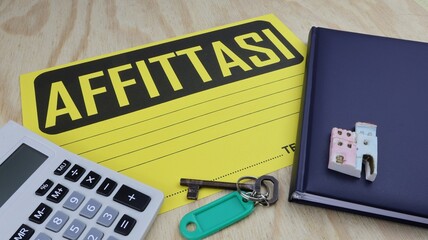 Cartello AFFITTASI con la scritta in italiano e spazio vuoto per scrivere. sulla scrivania con...