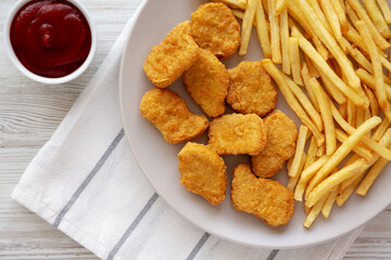 Fried Chicken Nuggets with French Fries on a Plate, top view. Overhead, from above, flat lay.