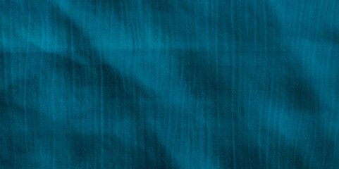 A blue fabric with a pattern of blue and white.. Blue nets background in the dark. emerald paper texture, background, copy space. Image of light rays over black. Waves made of satin stofin green blue.
