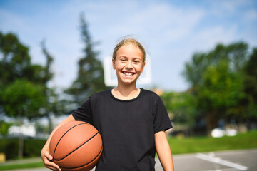 girl child in sportswear playing basketball game