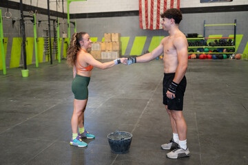 Man and woman shaking hands in gym after workout