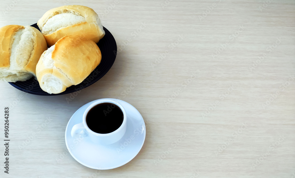 Wall mural some french bread dinner rolls on the table and cup of coffee with large copy space.