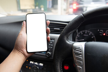 hand holding a smartphone with a blank screen inside a car, depicting the use of mobile technology for navigation or communication while driving. Transportation, mobile technology, automotive