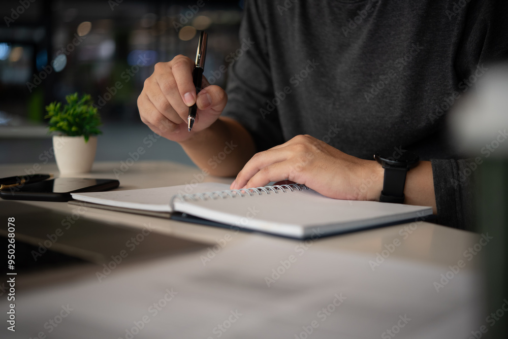 Aufkleber person writing notes in a notebook in an office setting, capturing the process of planning, brainsto