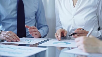 Business people are reviewing a financial results and discussing the terms of the agreement. Teamwork and planning