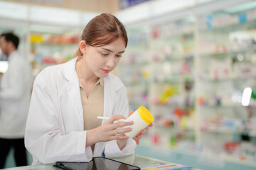 A woman pharmacist inspects a medication bottle, ensuring accuracy in prescription filling....
