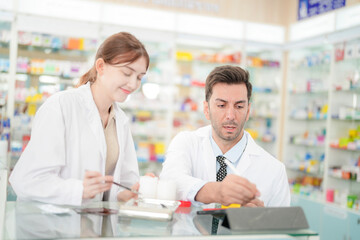 team man and woman pharmacist inspects a medication bottle, ensuring accuracy in prescription...