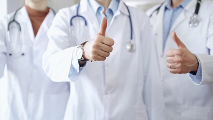 Group of doctors are are standing and showing thumbs up in hospital corridor. Medicine excellent service