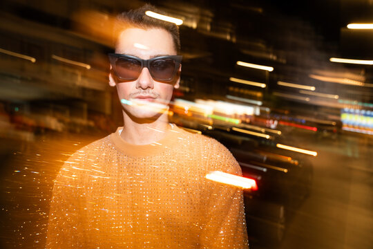 Non-binary Individual poses amid dynamic light streaks