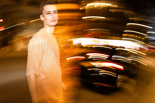 Non-binary Individual poses amid dynamic light streaks