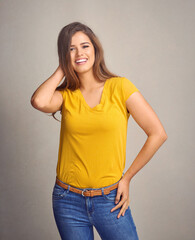 Woman, happy and confidence in studio for fashion, cool and trendy outfit with jeans, pride and smile. Female person, portrait and casual wear on gray background for style, aesthetic and chic clothes
