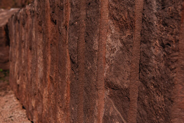 Close-up of red sandstone from the quarry with traces of drilled holes