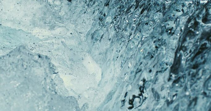 Super slow motion macro of waterfall fresh clean pure water stream is flowing down surrounded by rocks nature in natural habitat at 1000 fps.