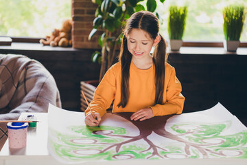 Photo portrait of charming little girl sit table draw family tree dressed orange garment spend...