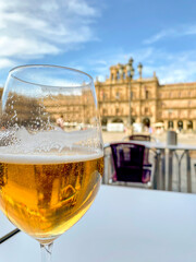 glass of cold blonde beer with foam in Salamanca square with the background out of focus