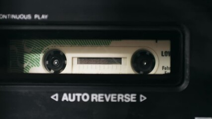 Retro radio tape recorder, audio cassette close-up. Listening to music, old radio boom box player, macro of vintage music listening. 