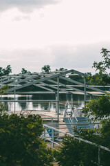 Summer area made of a pier and a metal structure as a frame for the roof. An abandoned place to relax on a calm river in the soft light of the sun before sunset.

