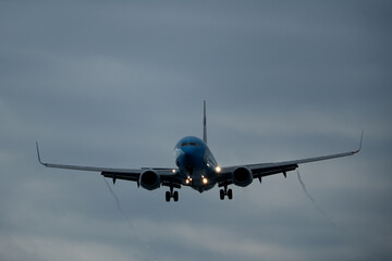 Airplane in the cloudy sky. Landing.