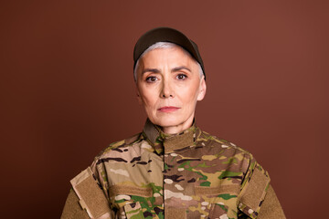 Photo of confident strong retired woman wear camouflage empty space isolated brown color background