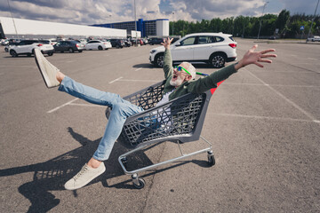 Full body photo of senior man car riding have fun enjoy summer weekend shopping cart mall parking