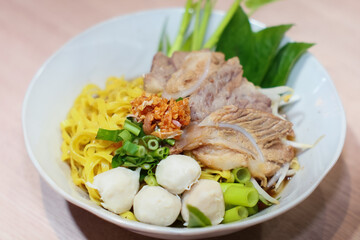 Yellow noodles decorated with pork meatballs, sliced ​​pork, vegetables and pork blood soup.