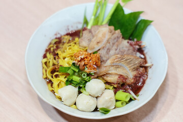 Yellow noodles decorated with pork meatballs, sliced ​​pork, vegetables and pork blood soup.