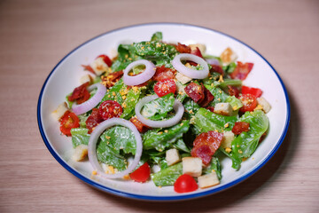 Healthy vegetable salad of fresh tomato, onion, lettuce  on plate. Diet menu. Top view.