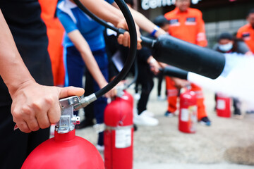 Employees firefighting training, Concept Employees hand using fire extinguisher fighting fire...