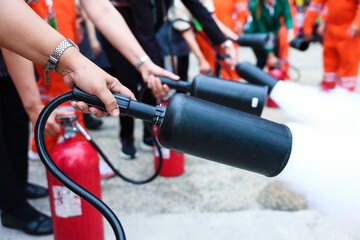 Employees firefighting training, Concept Employees hand using fire extinguisher fighting fire...