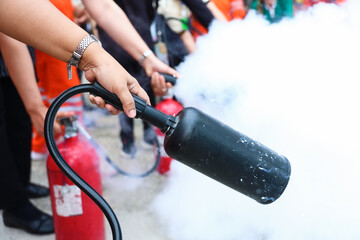 Employees firefighting training, Concept Employees hand using fire extinguisher fighting fire...