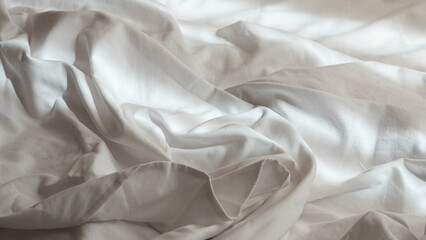 Obraz premium Photograph of the detail of discarded sheets on a luxury hotel bed.