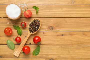 Fresh tomatoes, basil, sea salt and spices on wooden background, top view